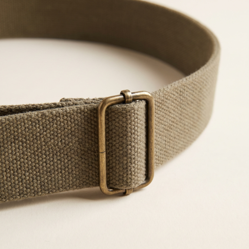 Brigitte belt buckle and strap detail on a cream studio backdrop