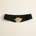Coralie wide black elastic waist belt with a gold leaf clasp, on a cream studio backdrop