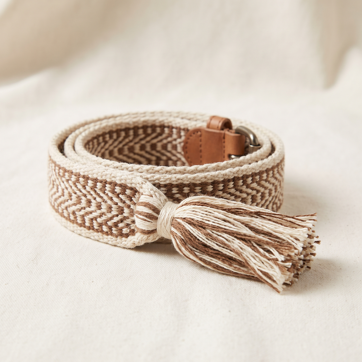 Estelle belt buckle and strap detail on a cream studio backdrop