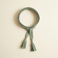 Estelle sage woven tie belt with long tassels, looped on a cream studio backdrop