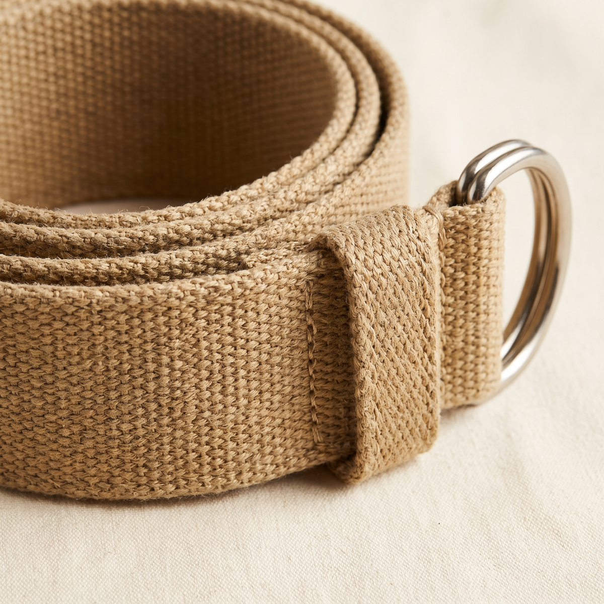 Nadege belt buckle and strap detail on a cream studio backdrop