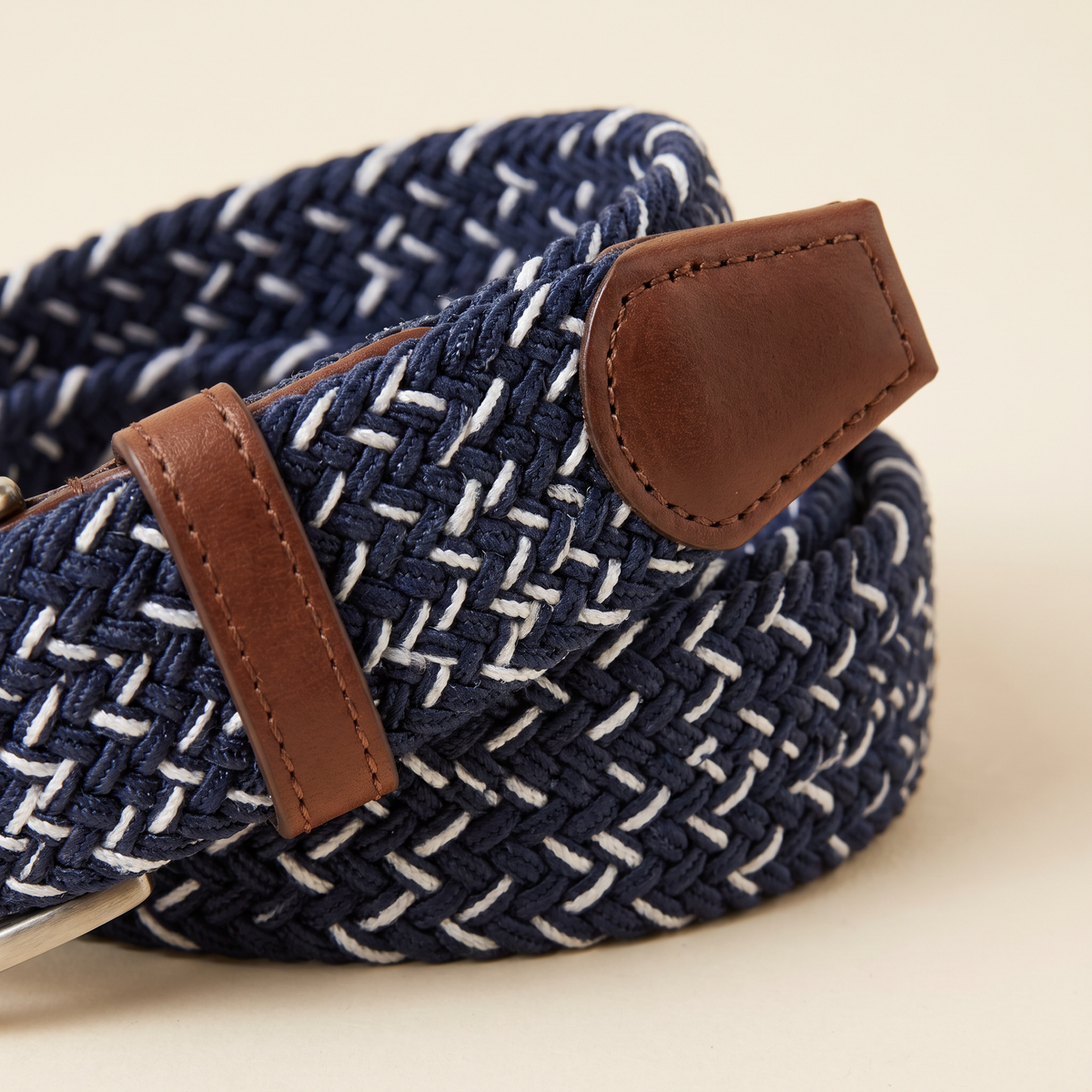 Oceane belt buckle and strap detail on a cream studio backdrop
