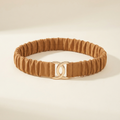 Veronique wide camel ruched elastic belt with a gold clasp, on a cream studio backdrop